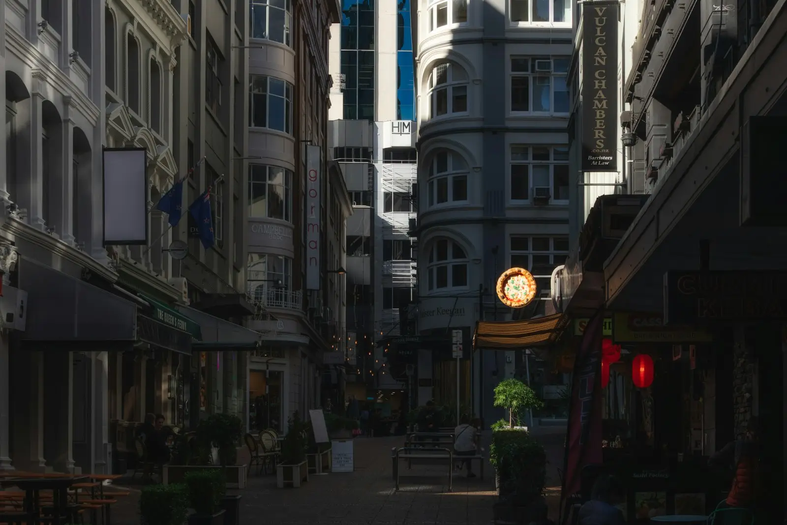 Historic buildings and lit shopfronts on a narrow city street