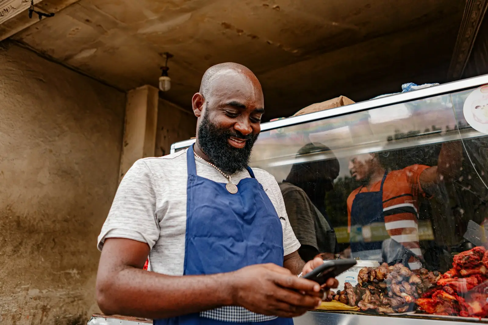 Business owner in an apron checking his phone
